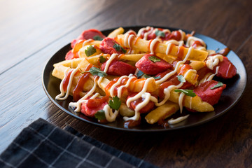 Homemade Peruvian Salchipapa Fries with Sausage Slices, Ketchup and Mayonnaise.