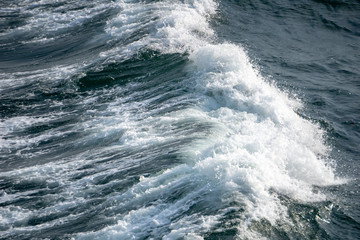 Fototapeta na wymiar Wave form and water splash created by vessel sail through the sea or ocean