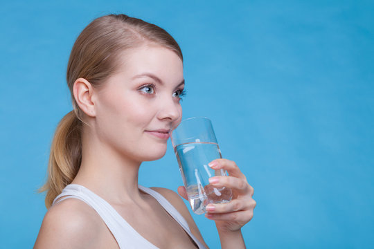 Woman holding and drinking a glass of water