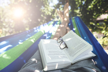 Man Laying In Hammock Reading Book