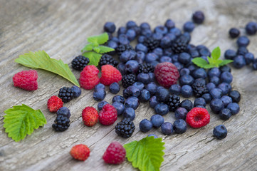 mix of blueberries, blackberries, raspberries on old wooden table background