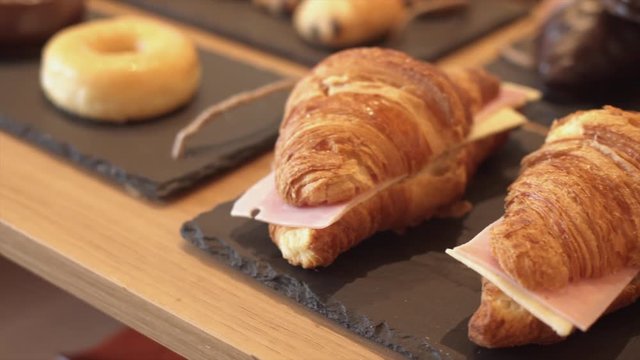 Variety of fresh croissants in a bakery store.