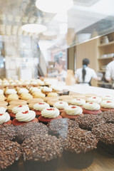 Many flavours cupcakes with testy cream on the bar