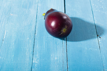 eggplant with shade on blue wood table
