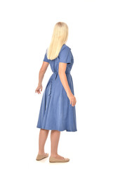 full length portrait of blonde girl wearing blue dress. standing pose with back to the camera. isolated on white  studio background.