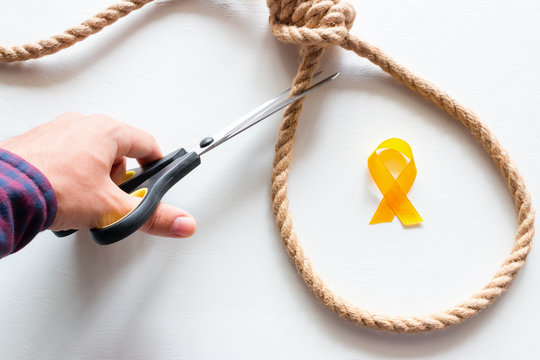 cuts the noose. yellow ribbon symbol of stop suicide