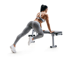 Fitness woman doing exercise leaning on sports bench. Photo of attractive latin woman in...
