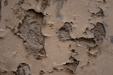 Old exterior concrete wall with peeled off paint