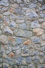 Close up view of a stone block wall of granite, different shape, rough abstract background surface texture architectural photo
