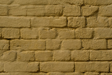 Exterior brick wall painted in yellow color