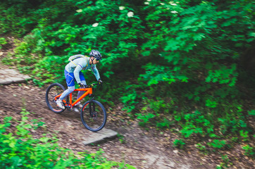 A cyclist in a helmet is riding off-road, motion blur