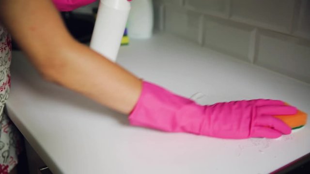 Woman cleaning kitchen counter. Household equipment, spring-cleaning, tidying up, cleaning service concept.
