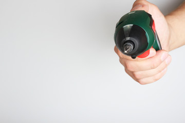 electric screwdriver in hand on a light background