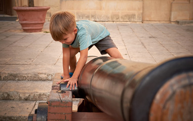 4 years old boy playing with canon in Mdina Malta