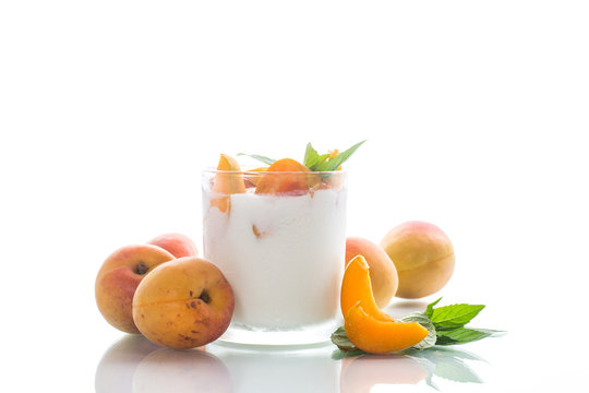 homemade yogurt with ripe apricots on a white