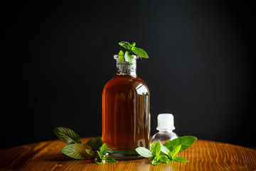 Mint syrup in a glass bottle on a black background
