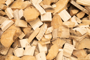 Waste wood, waste sawmill. Firewood for heating in winter. Wooden kurbets, sawn on a sawmill. A pile of firewood sawn on a sawmill. Background with bright light wood.