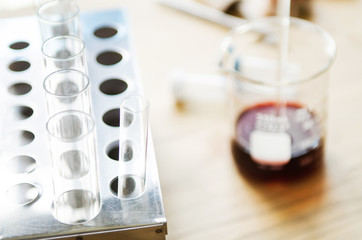 A pipette dropping sample into a test tube,abstract science background