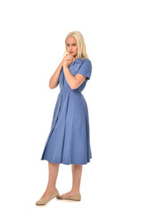 full length portrait of blonde girl wearing blue dress. standing pose. isolated on white  studio background.