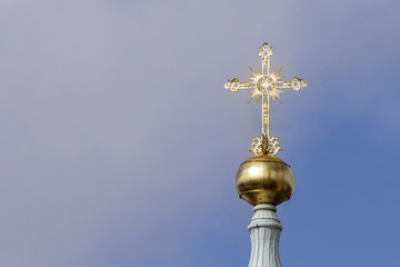 Gold cross against blue sky