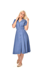 full length portrait of blonde girl wearing blue dress. standing pose. isolated on white  studio background.