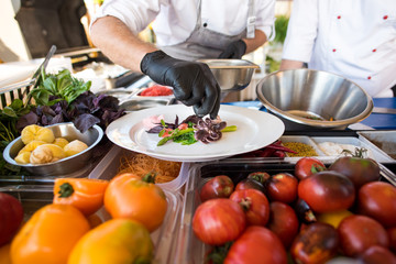 A cook preparing delicious dish with little octopuses at the open air restaurant