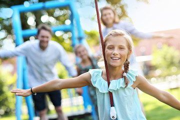 Joyful family having fun on playground