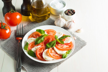 Close-up photo of caprese salad with ripe tomatoes, basil, buffalo mozzarella cheese. Italian and Mediterranean food concept. Fresh and healthy organic meal. Starter and antipasti. 