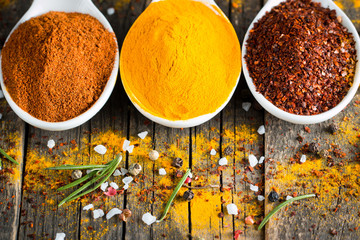Spices in Wooden spoon. Herbs. Curry, Saffron, turmeric, rosemary, cinnamon, garlic, pepper, anise on wooden rustic background. Collection of spices and herbs. 