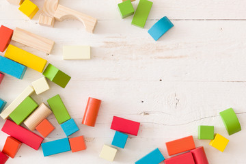 colorful wooden toy blocks on white wooden table background.