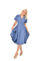 full length portrait of blonde girl wearing blue dress. standing pose. isolated on white  studio background.
