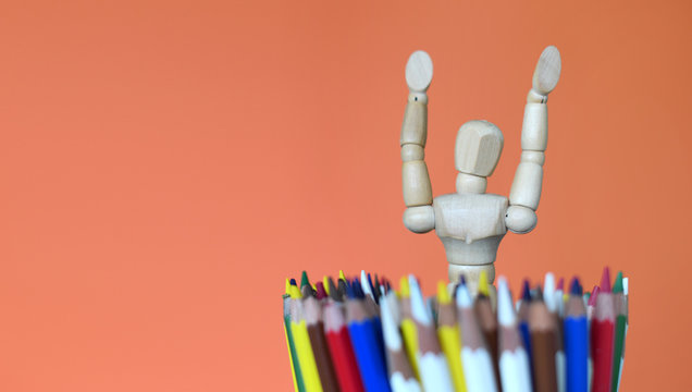 Wood mannequin figure with colorful pencils. Concept of art supplies, creativity and education