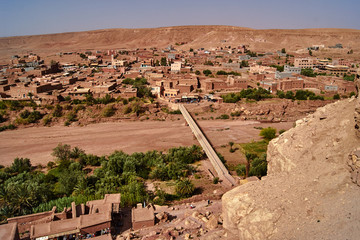 Fototapeta na wymiar A bridge over a dried-up river and the buildings of the settlement .of Ait Ben Haddouw in Morocco.