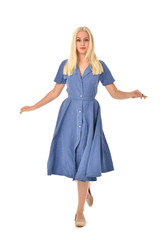 Fototapeta premium full length portrait of blonde girl wearing blue dress. standing pose. isolated on white studio background.