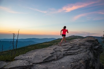 Fototapeta premium Young woman running on rocks.