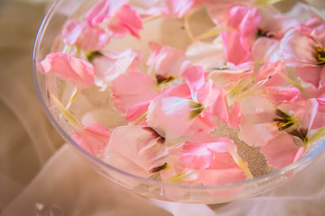 Obraz na płótnie Canvas Bowl of water with flower petals