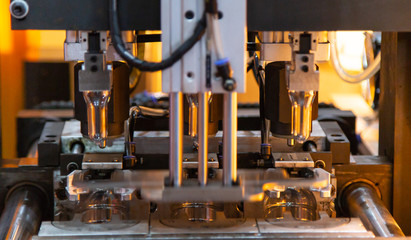 Production of plastic bottle on bottle blowing machine. Industrial manufacturing