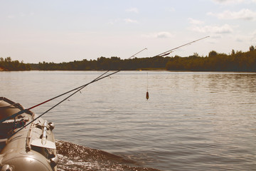 boat with a fishing rod and spinning on the background of a river