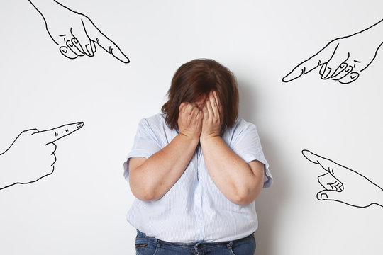 femme ronde pleurant contre un mur