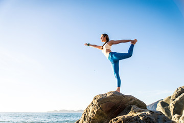 Woman doing yoga on the beach