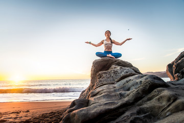 Woman doing yoga on the beach