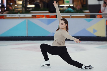 Fototapeta na wymiar Cute girl figure skating at sports arena
