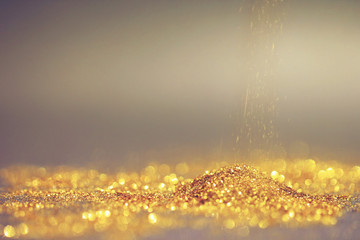 Close up of Sprinkle gold dust and glitter lights on dark background