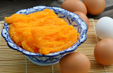 Golden egg strip is Thai desserts made from eggs with Thai style bowl on wooden background ( Thai name is Foi Thong).