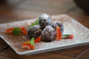 Homemade Raw Truffles or Energy Balls filled with Coconut, Almond and Cacao, Dark Chocolate and Hazelnut. Healthy food
