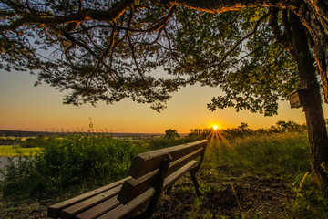 Holzbank auf dem Land im Sonnenuntergang