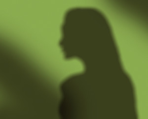 Shadow of a woman on the green wall
