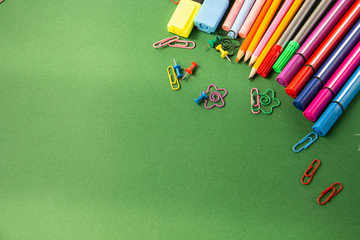 Office supplies for school on a green background with a blank sp