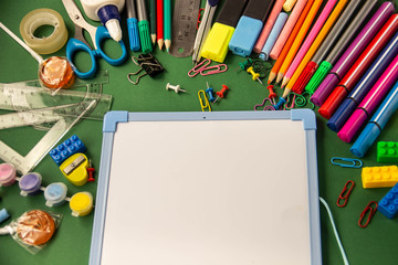 Office supplies for school and a drawing board on a green backgr