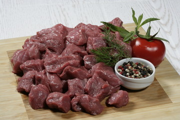 Raw chopped beef on a wooden cutting board on a slate
